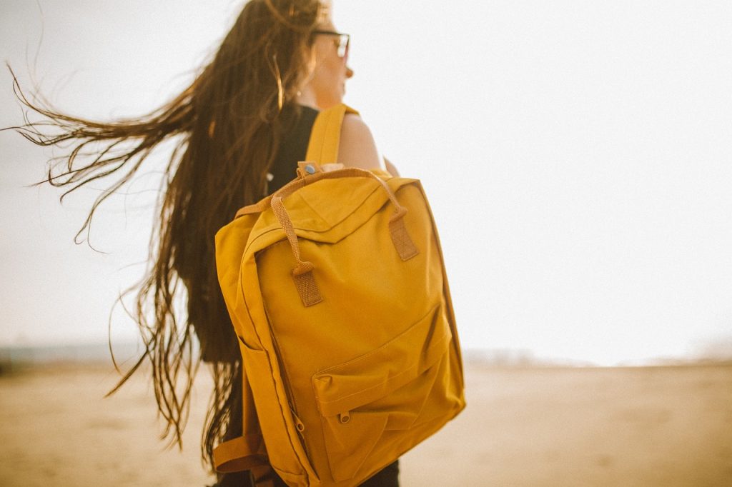 jeune fille portant un sac à dos jaune